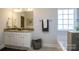 Bathroom with granite vanity, large mirror, soaking tub, and a window for natural light at 255 Eason St, Bowdon, GA 30108