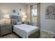 Bedroom with bedside tables, decorative chandelier art, and a window for natural light at 255 Eason St, Bowdon, GA 30108