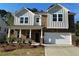 Two-story home featuring a two-car garage, brick and siding exterior, and a covered front porch at 3321 Burkston Pl, Buford, GA 30519