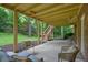 Relaxing back patio featuring outdoor seating, exposed ceiling beams and stairs that lead to backyard at 210 Malvern Pl, Roswell, GA 30076