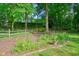 Landscaped backyard with a split rail fence and garden area at 210 Malvern Pl, Roswell, GA 30076