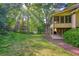 Wide backyard featuring a deck, screened porch, lush lawn, and mature trees at 210 Malvern Pl, Roswell, GA 30076
