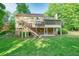 Expansive backyard with a deck, screened porch, lush lawn, and mature trees at 210 Malvern Pl, Roswell, GA 30076