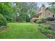 Green backyard featuring a well-maintained lawn and partial view of the house with a screened-in porch at 210 Malvern Pl, Roswell, GA 30076