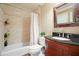 Bathroom with shower over tub, a wooden vanity, and decorative framed mirror, offering style and functionality at 210 Malvern Pl, Roswell, GA 30076