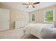 Bright bedroom featuring neutral walls, carpet, ceiling fan, and a matching dresser and door at 210 Malvern Pl, Roswell, GA 30076