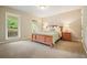 Cozy bedroom with neutral carpet, a large window overlooking the backyard, and ample natural light at 210 Malvern Pl, Roswell, GA 30076