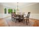Formal dining room featuring hardwood floors, traditional chandelier, and bright bay window overlooking lush greenery at 210 Malvern Pl, Roswell, GA 30076