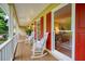 Inviting front porch with rocking chairs, red shutters, and stylish exterior lighting at 210 Malvern Pl, Roswell, GA 30076
