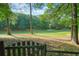 Scenic view of the golf course, framed by mature trees and a quaint wooden fence at 210 Malvern Pl, Roswell, GA 30076