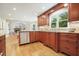 Eat-in kitchen with stainless steel appliances, wood cabinets, granite countertops, and hardwood floors at 210 Malvern Pl, Roswell, GA 30076