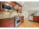 Gourmet kitchen with stainless steel appliances, granite countertops, and custom wood cabinets with breakfast bar at 210 Malvern Pl, Roswell, GA 30076