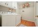 Bright laundry room with wood floors, white cabinets, and modern washer and dryer at 210 Malvern Pl, Roswell, GA 30076