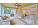 Enclosed sunroom featuring wicker furniture, ceiling fan, and backyard views at 210 Malvern Pl, Roswell, GA 30076