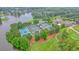 Aerial view of four tennis courts next to a lake, lush landscaping, and a clubhouse at 210 Malvern Pl, Roswell, GA 30076