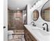 Modern bathroom featuring double sinks, wood cabinets, and a walk-in shower with pebble floor at 4392 Lower Fayetteville Rd, Sharpsburg, GA 30277