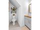 Compact bathroom featuring industrial shelving, stylish sink, and modern tile flooring at 4392 Lower Fayetteville Rd, Sharpsburg, GA 30277
