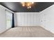 Spacious bedroom with neutral carpet, black painted ceiling, white walls and board and batten trim at 4392 Lower Fayetteville Rd, Sharpsburg, GA 30277