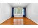 Formal dining room with hardwood floors, modern chandelier, and large window views at 4392 Lower Fayetteville Rd, Sharpsburg, GA 30277