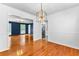 Bright dining room featuring wood floors, a modern light fixture, and an open layout to the kitchen at 4392 Lower Fayetteville Rd, Sharpsburg, GA 30277