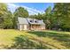 Charming home featuring a welcoming front porch, complemented by a spacious lawn and mature trees at 4392 Lower Fayetteville Rd, Sharpsburg, GA 30277