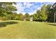 Expansive lawn in front of this charming home offers a picturesque view with mature trees and natural beauty at 4392 Lower Fayetteville Rd, Sharpsburg, GA 30277