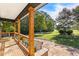 This covered stone patio offers a serene outdoor space with views of the lush, green surroundings at 4392 Lower Fayetteville Rd, Sharpsburg, GA 30277