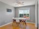 Bright dining area featuring a modern table set, ceiling fan and natural light from the large window overlooking the backyard at 502 Owens Springs Ln, Mcdonough, GA 30252