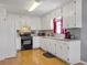 Updated kitchen with white cabinets, sleek appliances, and a view of the backyard through the window with red curtains at 502 Owens Springs Ln, Mcdonough, GA 30252