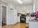 Bright, galley style kitchen with white cabinets and black appliances at 502 Owens Springs Ln, Mcdonough, GA 30252