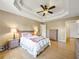 Spacious main bedroom with a trey ceiling, ceiling fan, hardwood floors, and a cozy king-size bed with lamps on the nightstands at 502 Owens Springs Ln, Mcdonough, GA 30252