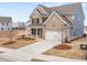 New construction home boasts a large driveway, attached garage, and a modern design with clean lines and neutral colors at 7164 Linden Dr, South Fulton, GA 30349