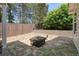 Backyard retreat featuring a stone fire pit and privacy fence at 123 Stoneforest Dr, Woodstock, GA 30189