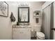 Bathroom featuring granite countertop, framed mirror, and chrome shelving at 123 Stoneforest Dr, Woodstock, GA 30189