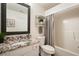Bathroom showcasing a granite countertop, framed mirror, and tub with shower curtain at 123 Stoneforest Dr, Woodstock, GA 30189