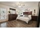 Bedroom features dark wood furniture, ceiling fan, and natural light from the door and window at 123 Stoneforest Dr, Woodstock, GA 30189