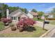 Charming brick home with a well-manicured lawn, mature trees, and a long concrete driveway at 123 Stoneforest Dr, Woodstock, GA 30189