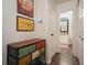Hallway with modern decor and colorful storage leading to a bright bathroom with white cabinets and a mirror at 123 Stoneforest Dr, Woodstock, GA 30189