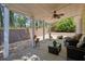 Covered outdoor patio featuring ceiling fan, comfortable seating, and landscaping at 123 Stoneforest Dr, Woodstock, GA 30189