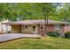 A well-kept brick home with a carport and a lush green lawn surrounded by mature trees at 1460 Briarcliff Ne Rd, Atlanta, GA 30306