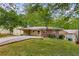 Charming brick home featuring a lush green lawn, carport, and mature shade trees at 1460 Briarcliff Ne Rd, Atlanta, GA 30306