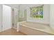 This bathroom has a tub and shower, a window, and neutral tiling at 1820 Lyon Sw Ave, Atlanta, GA 30331