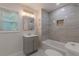 Bathroom featuring tiled shower over tub, light gray vanity, tiled floors, and a window for natural light at 214 Adeline Nw Ave, Atlanta, GA 30314