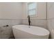 Freestanding bathtub with modern fixtures and marble tile at 214 Adeline Nw Ave, Atlanta, GA 30314