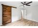 Cozy bedroom features a wooden barn door, ceiling fan, and light hardwood flooring at 2554 Gordon Se Cir, Smyrna, GA 30080