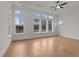 This bedroom features large windows, hardwood flooring, and a modern ceiling fan at 235 Strawberry Ln, Woodstock, GA 30189