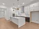 Bright kitchen with white cabinets, quartz countertops and stainless steel appliances at 235 Strawberry Ln, Woodstock, GA 30189