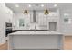Bright kitchen with an island, white cabinets, and pendant lights above a breakfast bar at 235 Strawberry Ln, Woodstock, GA 30189