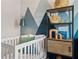 Bedroom with unique wall decor, a wood shelving unit, and a comfortable baby crib at 26 Kensington St, Kingston, GA 30145