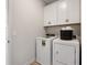 Functional laundry room with white cabinets, washer, dryer and storage options at 26 Kensington St, Kingston, GA 30145